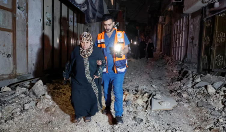 Banorët ecin në një rrugë të dëmtuar pas një bastisjeje izraelite në kampin Nur Shams, Tulkarm, në Bregun Perëndimor të pushtuar nga Izraeli, 20 prill 2024. REUTERS/Raneen Sawafta